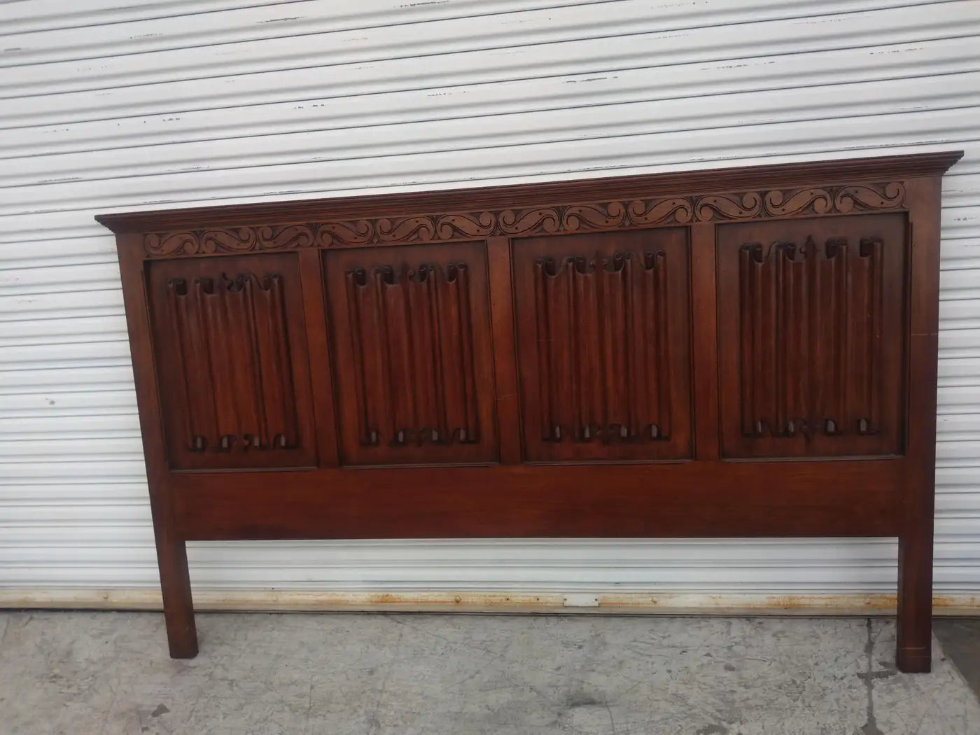 Ornate wooden headboard in rich mahogany finish