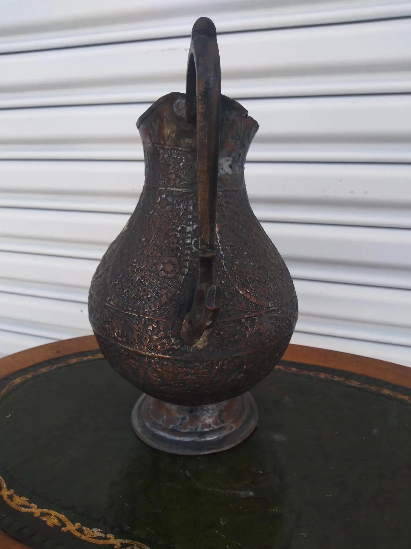 Detailed design of hand-crafted Middle Eastern metal pitcher