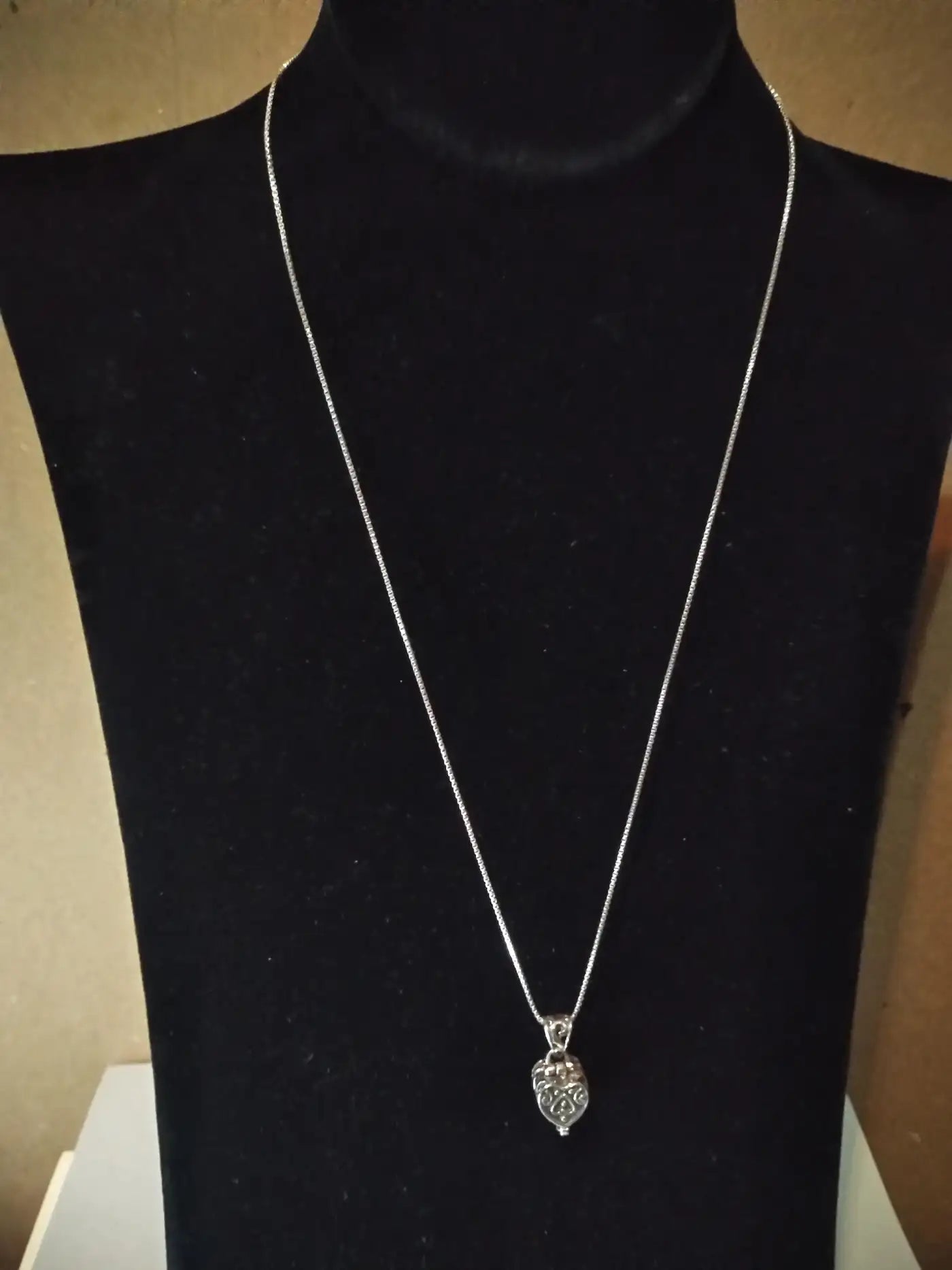 Silver heart-shaped locket pendant on chain
