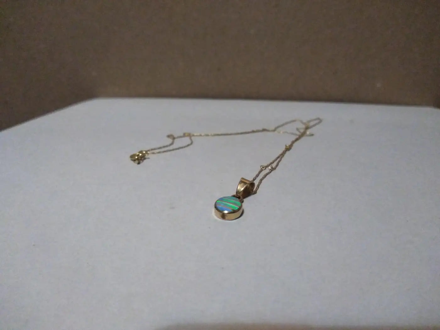 Delicate gold necklace featuring opal charm