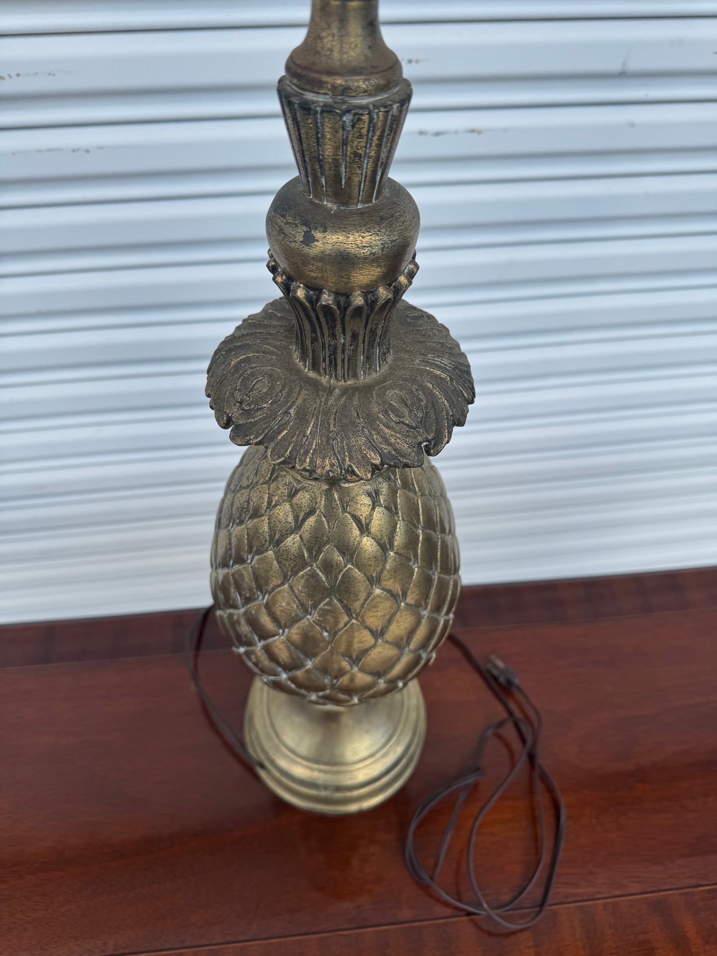 Antique brass pineapple lamp base highlighting geometric diamond patterns.
