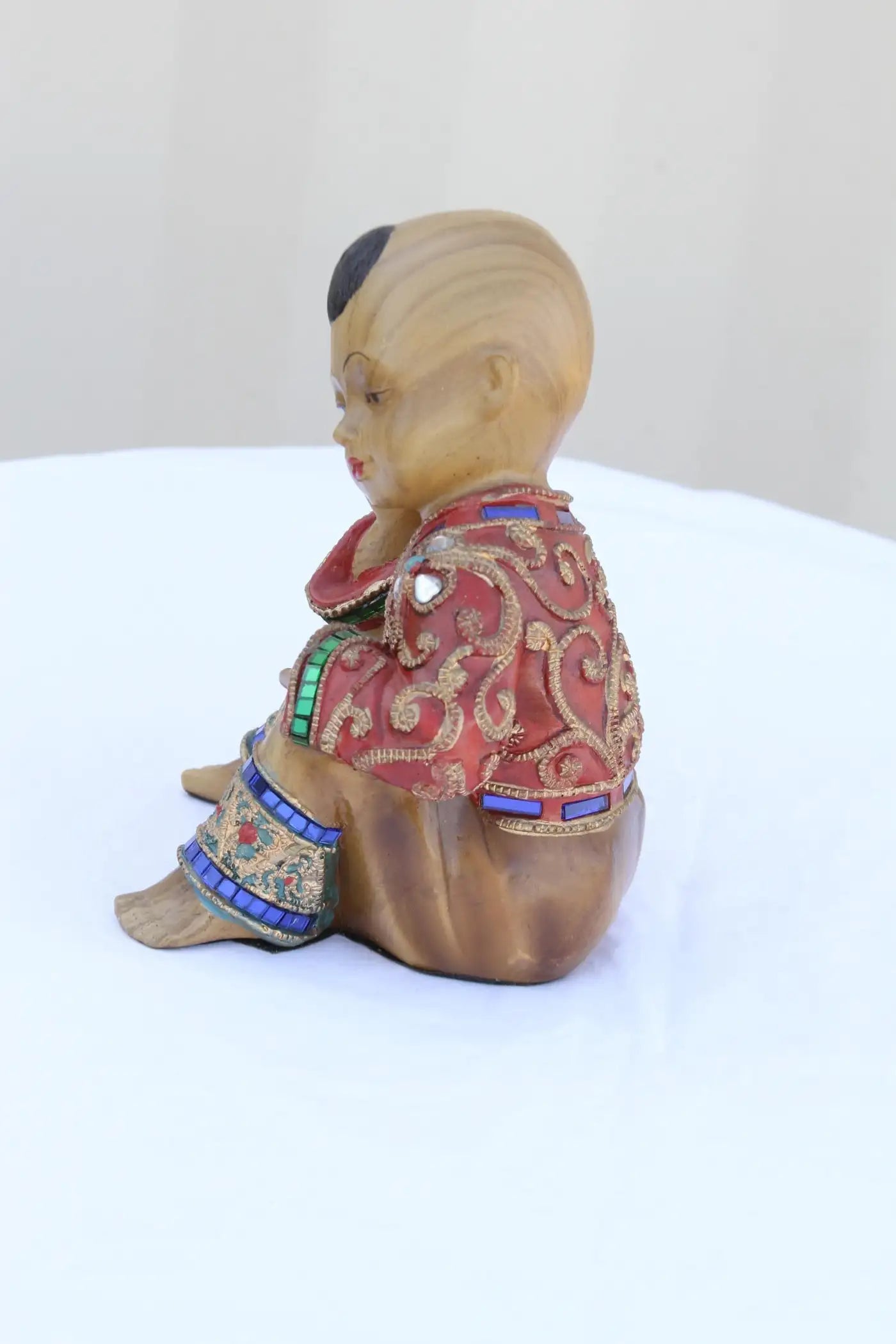 Intricate seated wooden figure adorned with gems