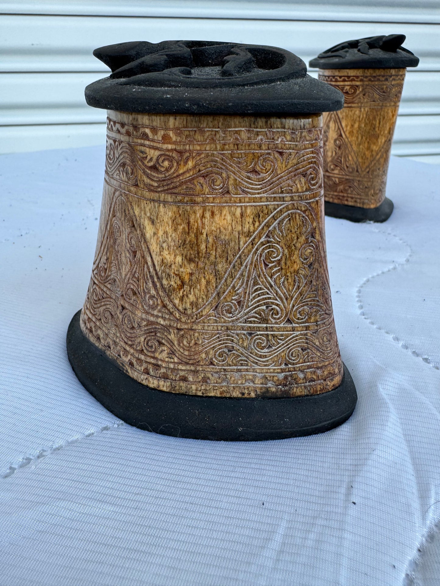 Set of two decorative bone containers featuring detailed ethnic patterns