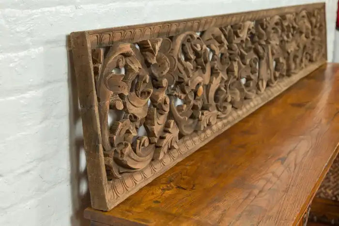 Decorative wood panel from Indonesia with temple and foliage motifs.