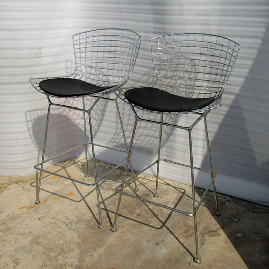Pair of Bertoia barstools from Knoll, featuring iconic wire mesh design for timeless style and comfort in modern living spaces.