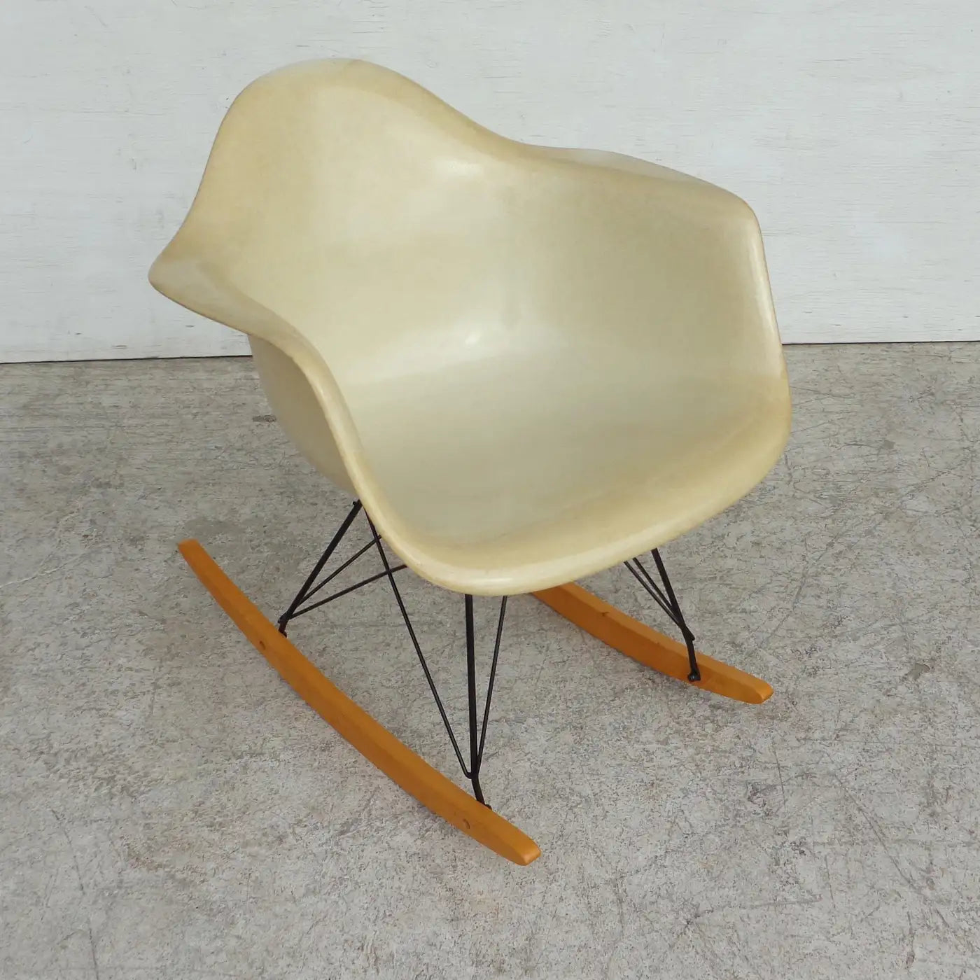 Iconic Eames orange fiberglass shell rocking chair