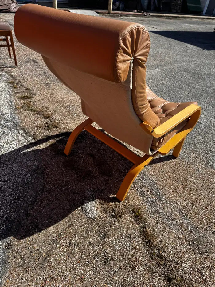 Sculptural wooden frame leather accent chair for modern interiors