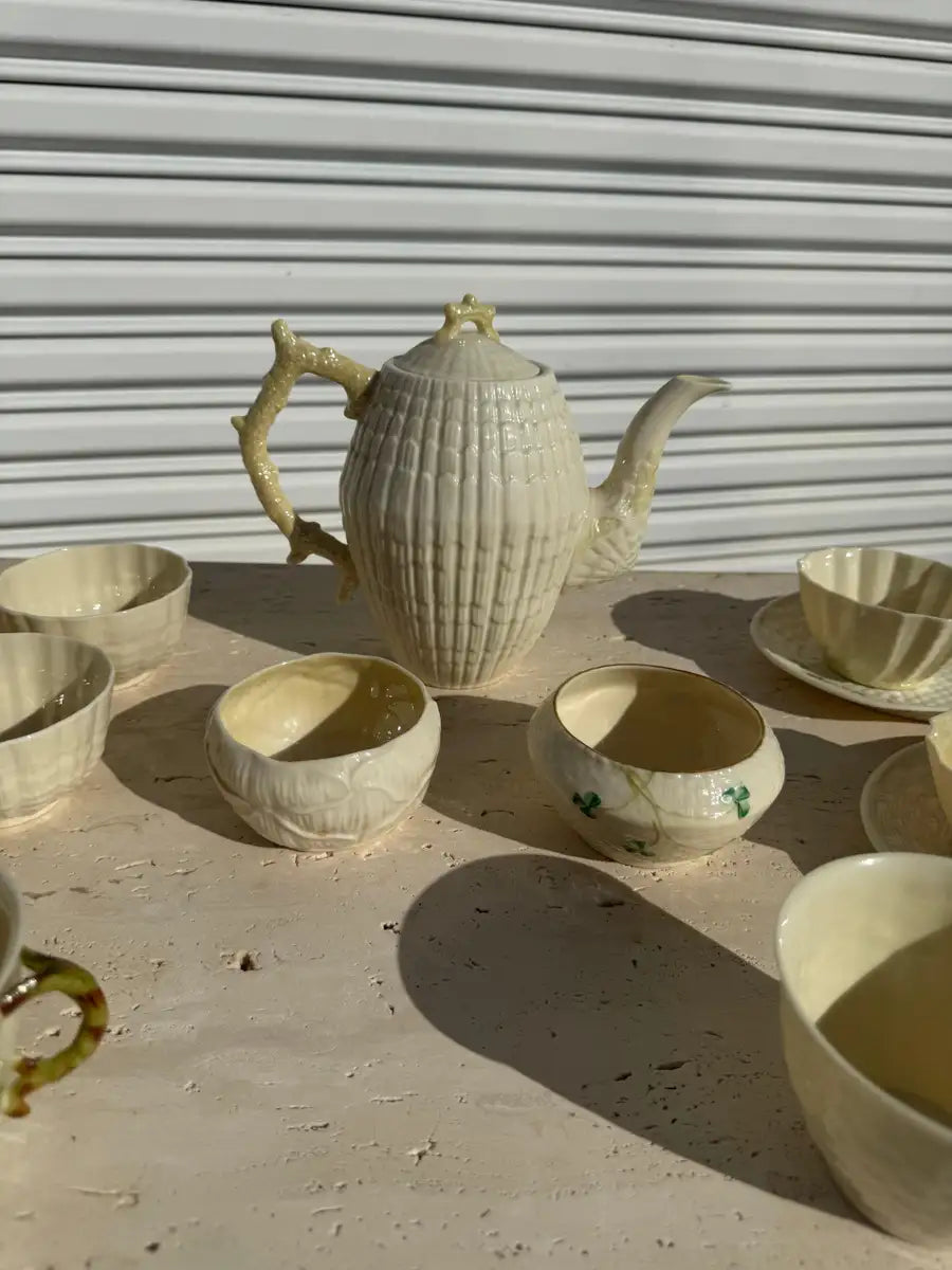 Antique porcelain teapot and cups with raised shell detailing