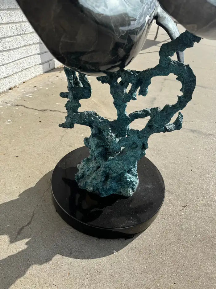 Marble top table supported by swimming dolphin sculpture