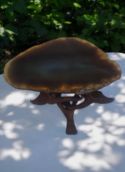 Brown agate geode crystal displayed on a wooden stand