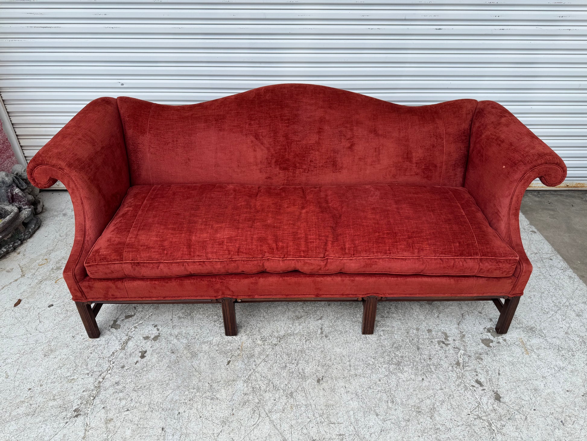 Traditional English Chippendale-style sofa with intricate carved legs and stretcher base