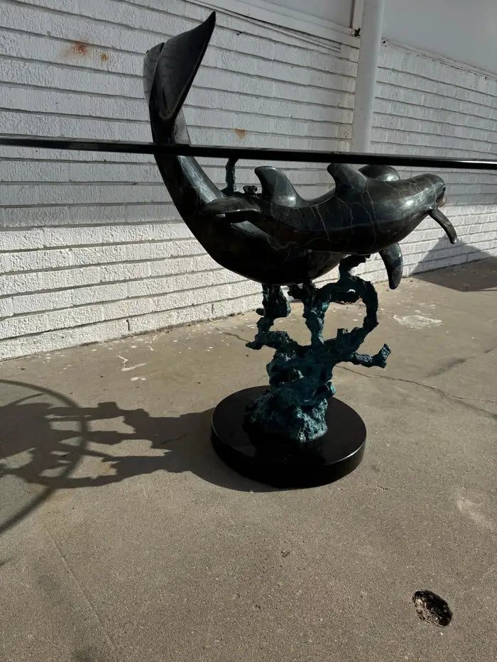 Sculptural dolphin table featuring detailed bronze casting