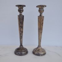 Tall sterling silver taper candle holders on marble background