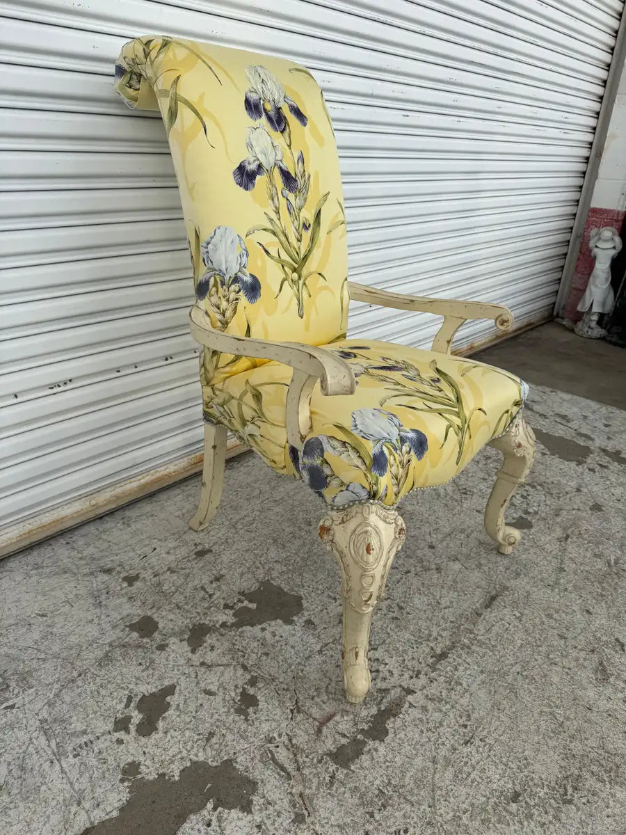 Upholstered French armchair with curved arms and carved legs