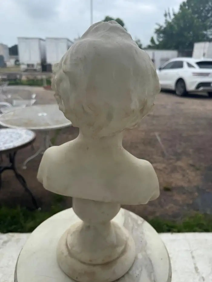 Antique marble artwork featuring classical youth figure