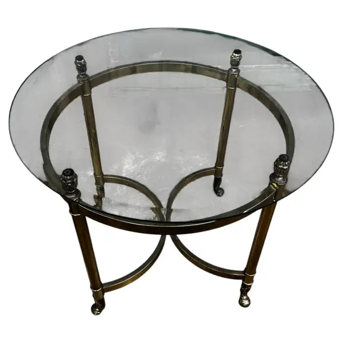 Glass top brass accent table on marble floor