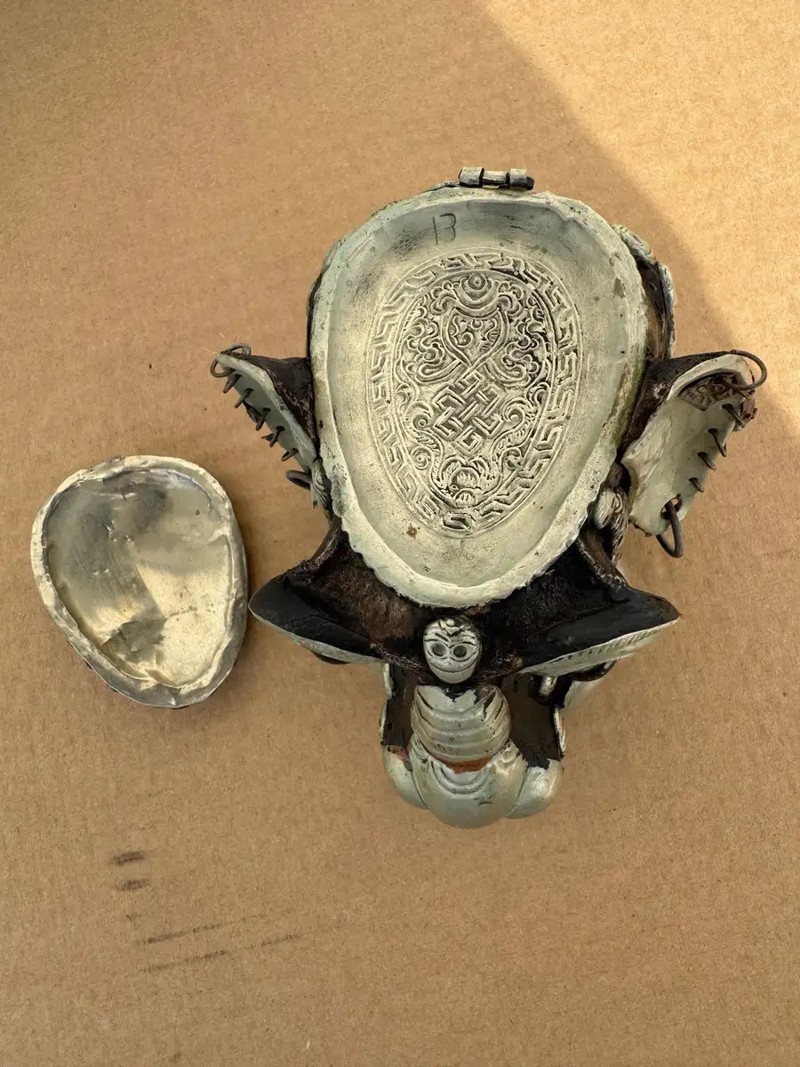 Tibetan skull art piece with metallic embellishments