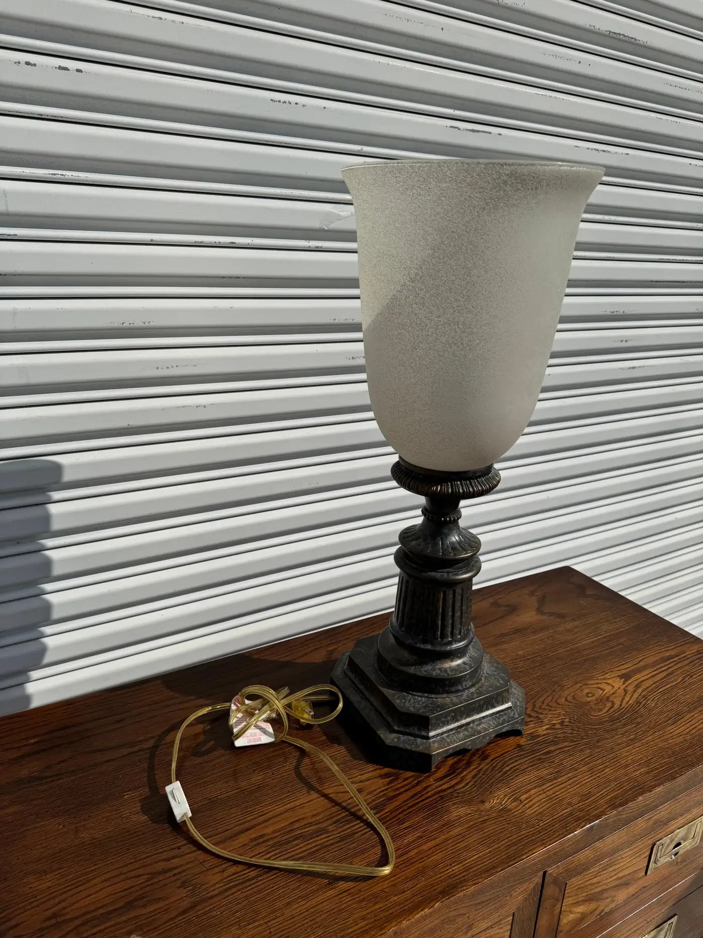 Decorative uplight lamp with metallic bronze finish and artistic touch.