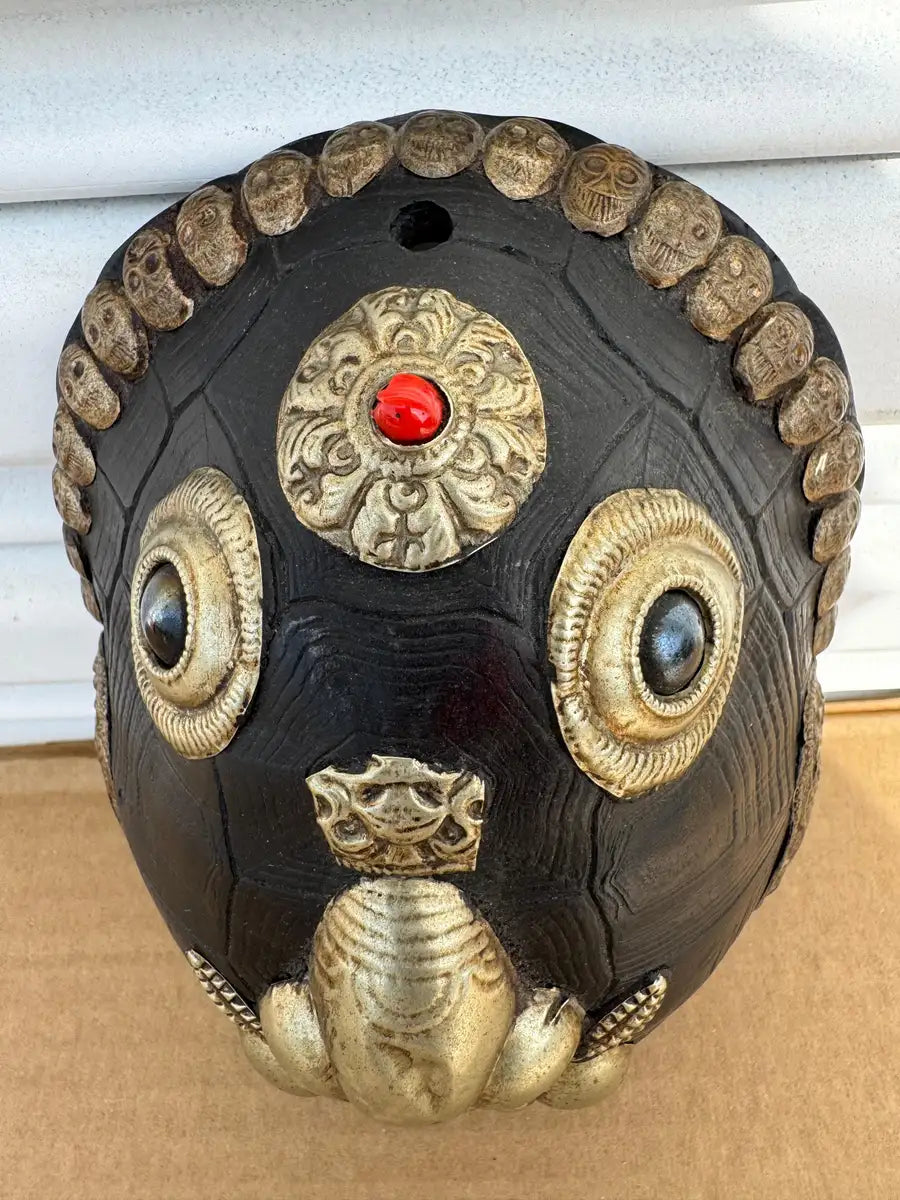 carved wood tribal mask with metal embellishments