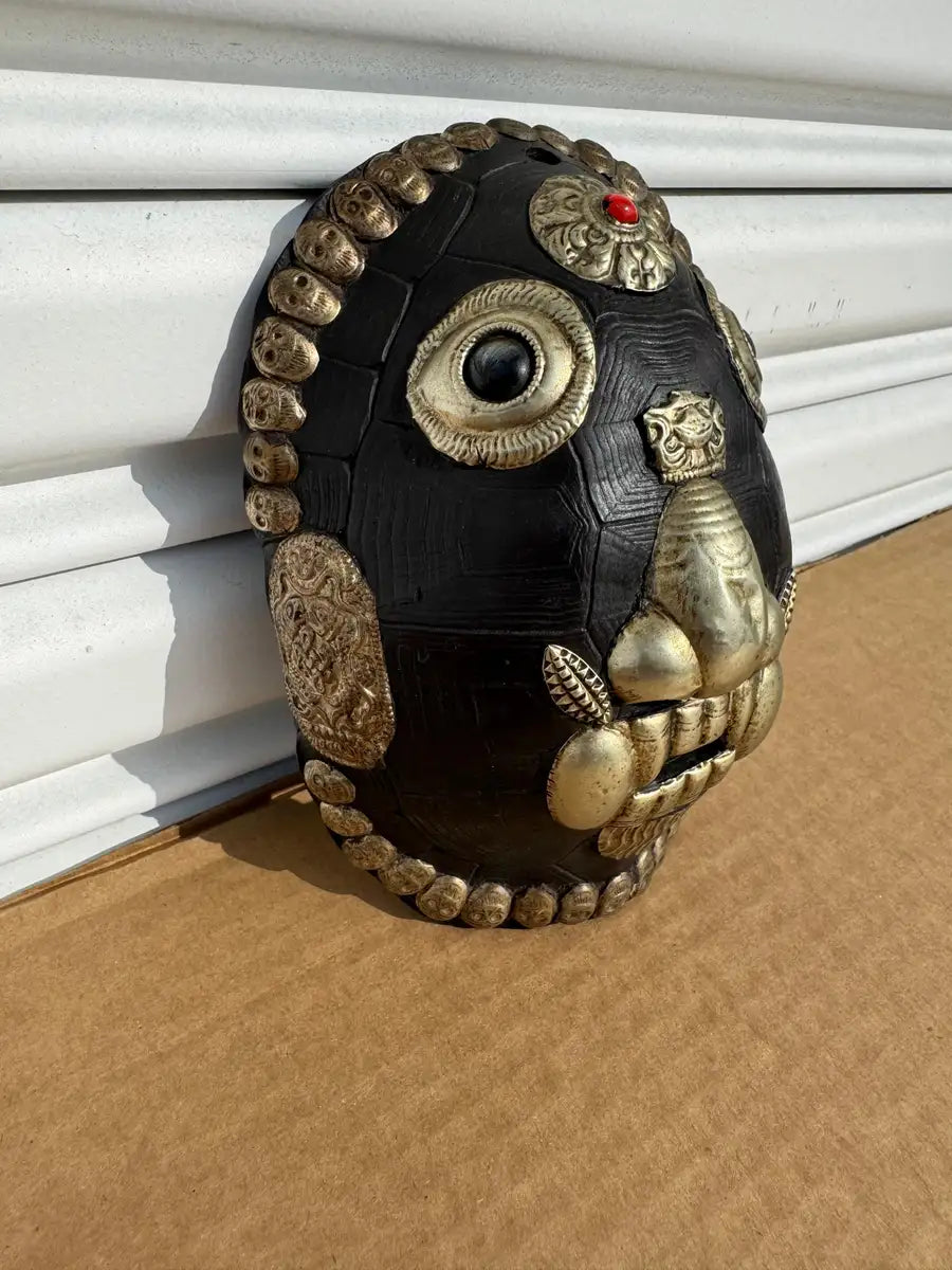 hand carved tribal mask with decorative metal details