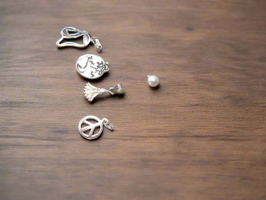 Set of 4 sterling silver pendants on white background