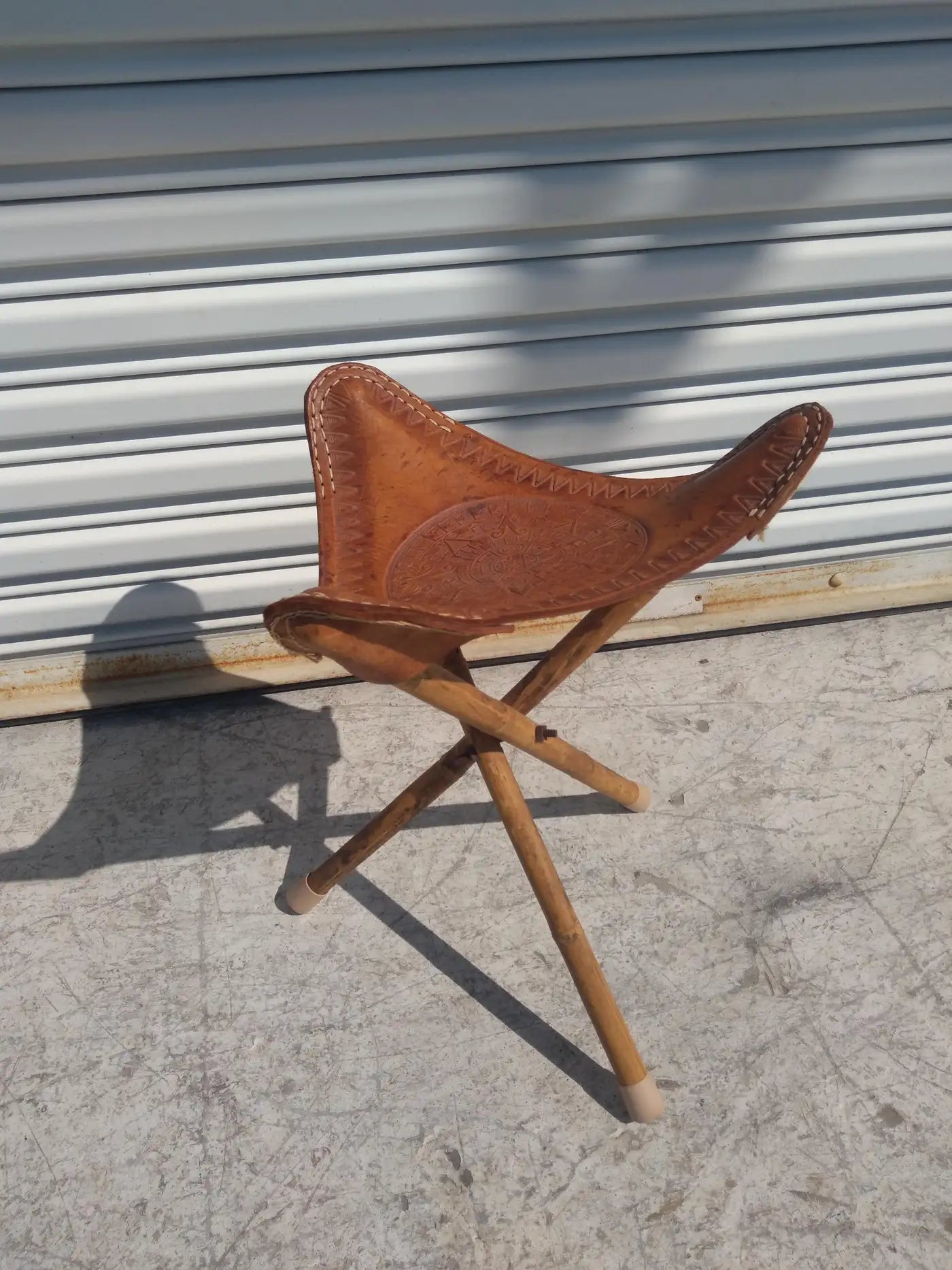 Rustic tripod stool made of bamboo and leather