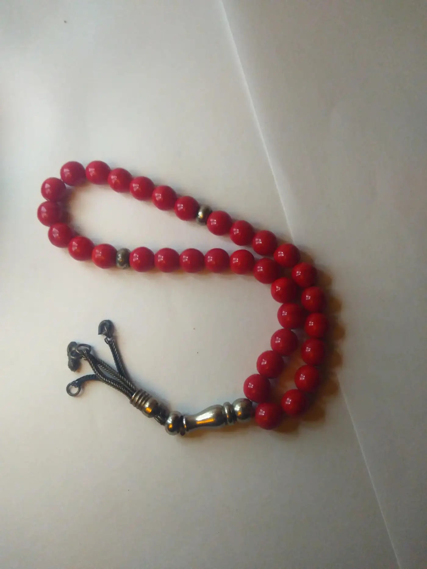 Close-up of red worry beads with silver details