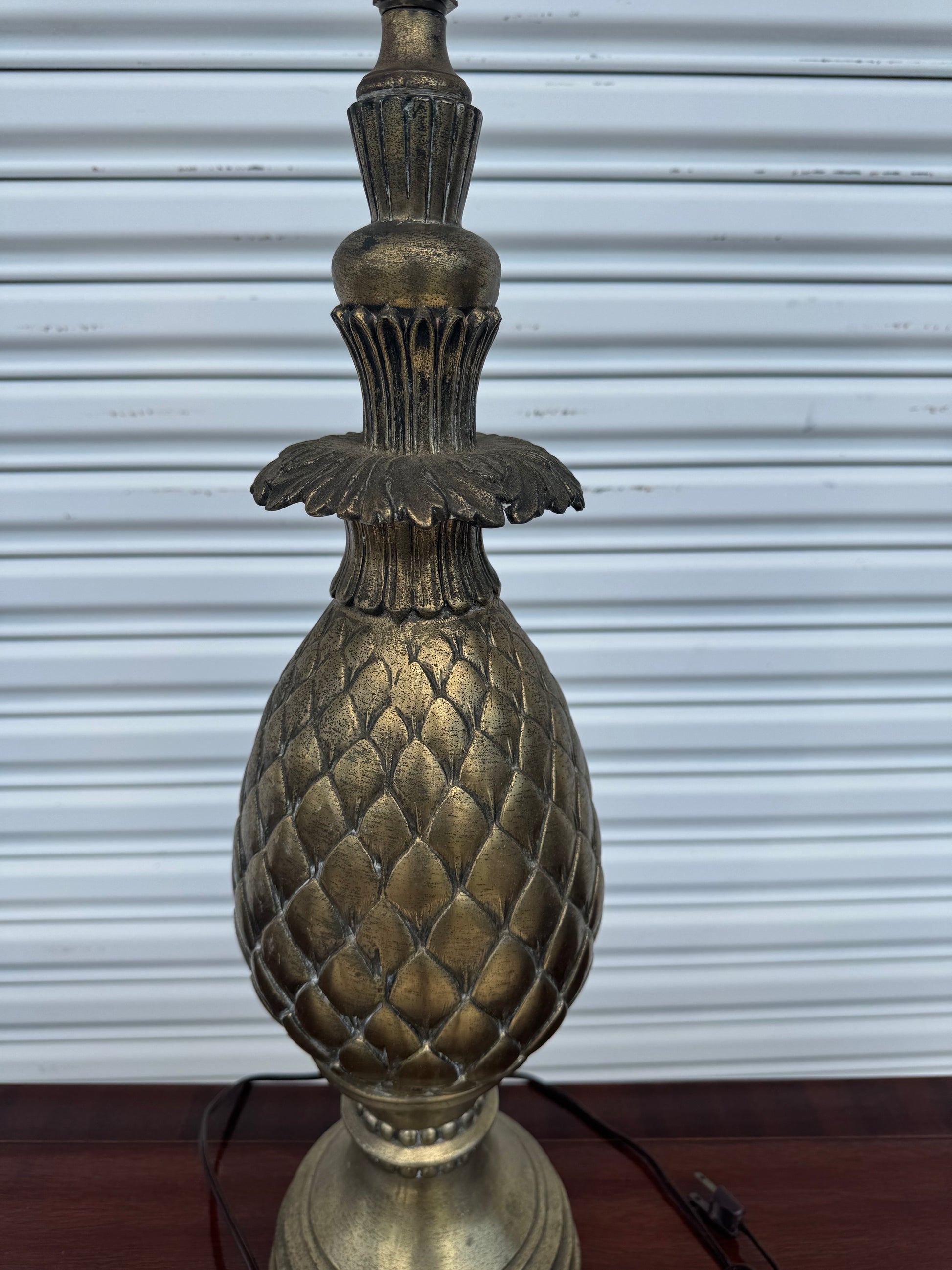 Close-up of Hollywood Regency pineapple lamp showing detailed carved texture and gold patina.