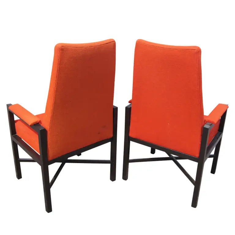 Iconic Wormley Dunbar high-back chairs vibrant red upholstery.​