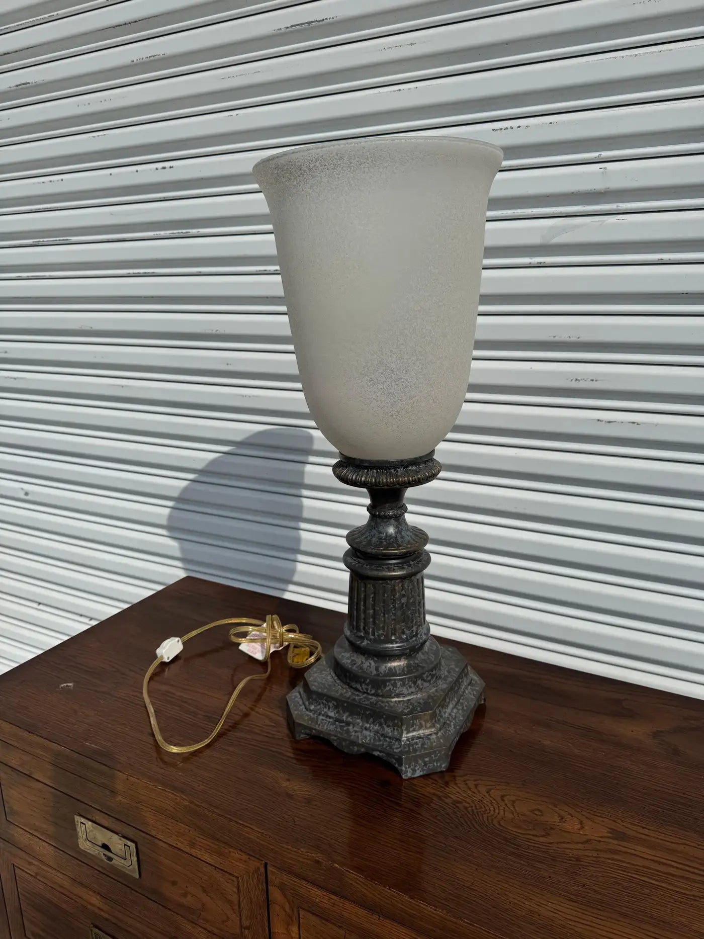 Bronze lamp with elegant pedestal and soft frosted glass uplighter.