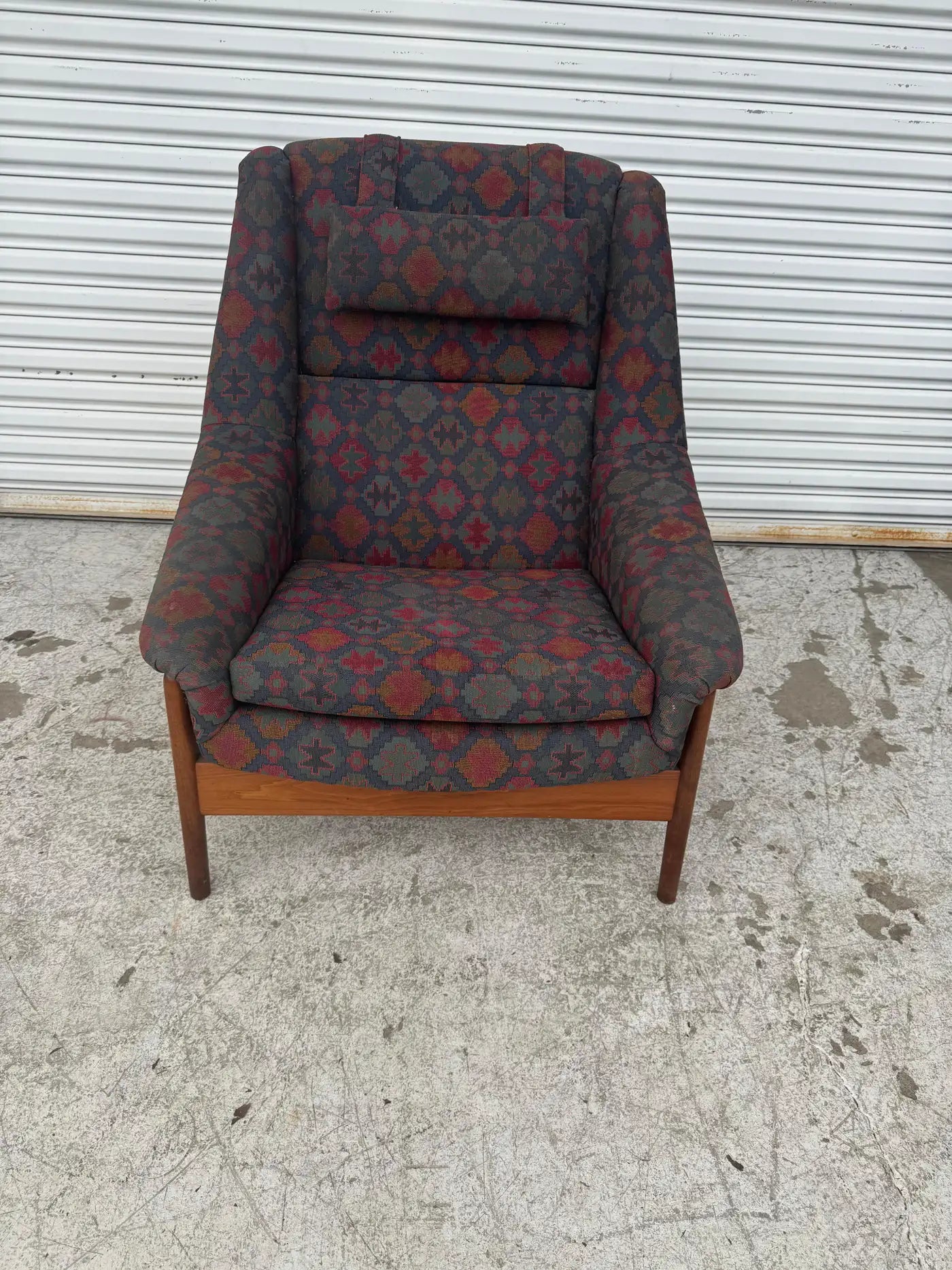 Front view of Folke Ohlsson teak lounge chair with bold kilim style upholstery ideal for design focused living room furniture.