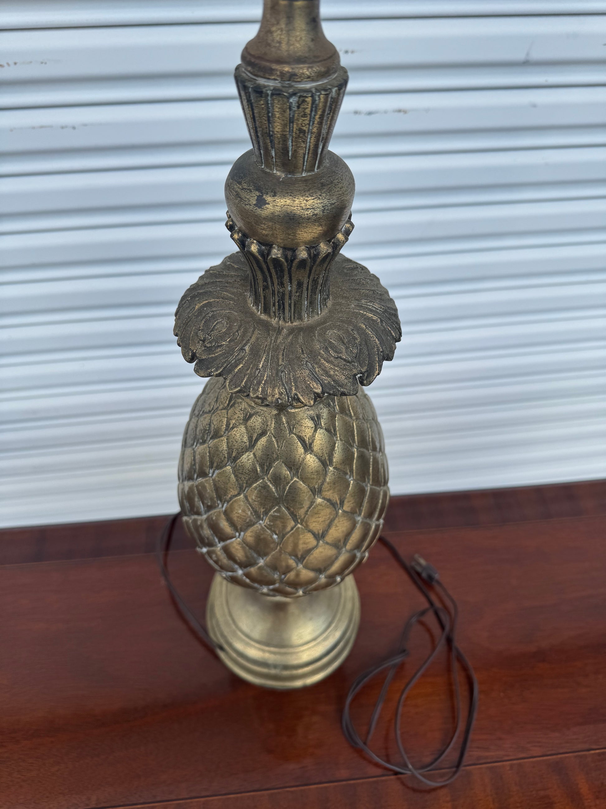 Antique brass pineapple lamp base highlighting geometric diamond patterns.