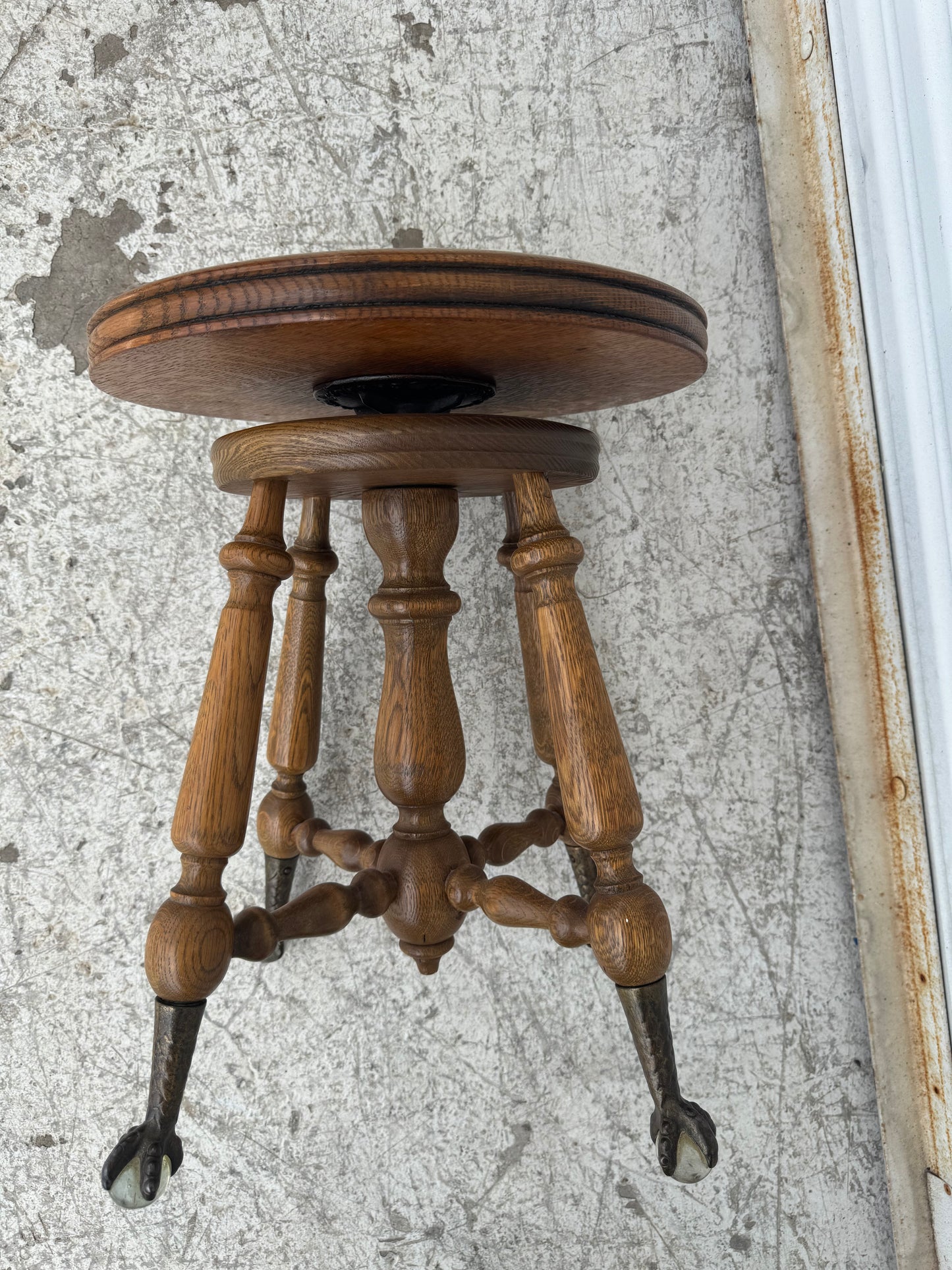Bottom view highlighting the detailed craftsmanship of the stool’s legs and ornate feet