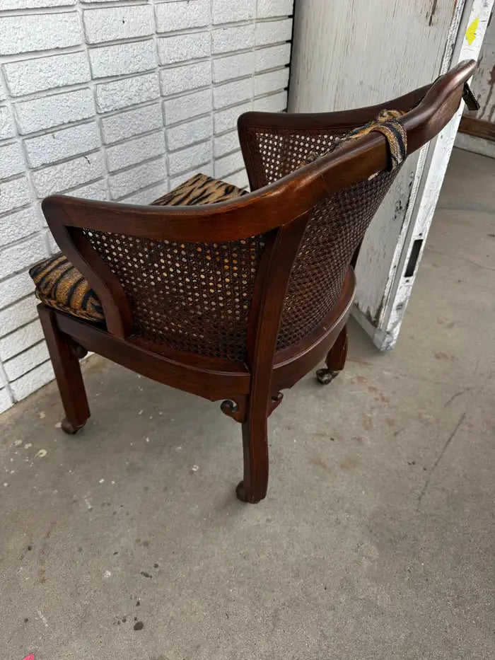 Antique style cane chair with carved wood and casters