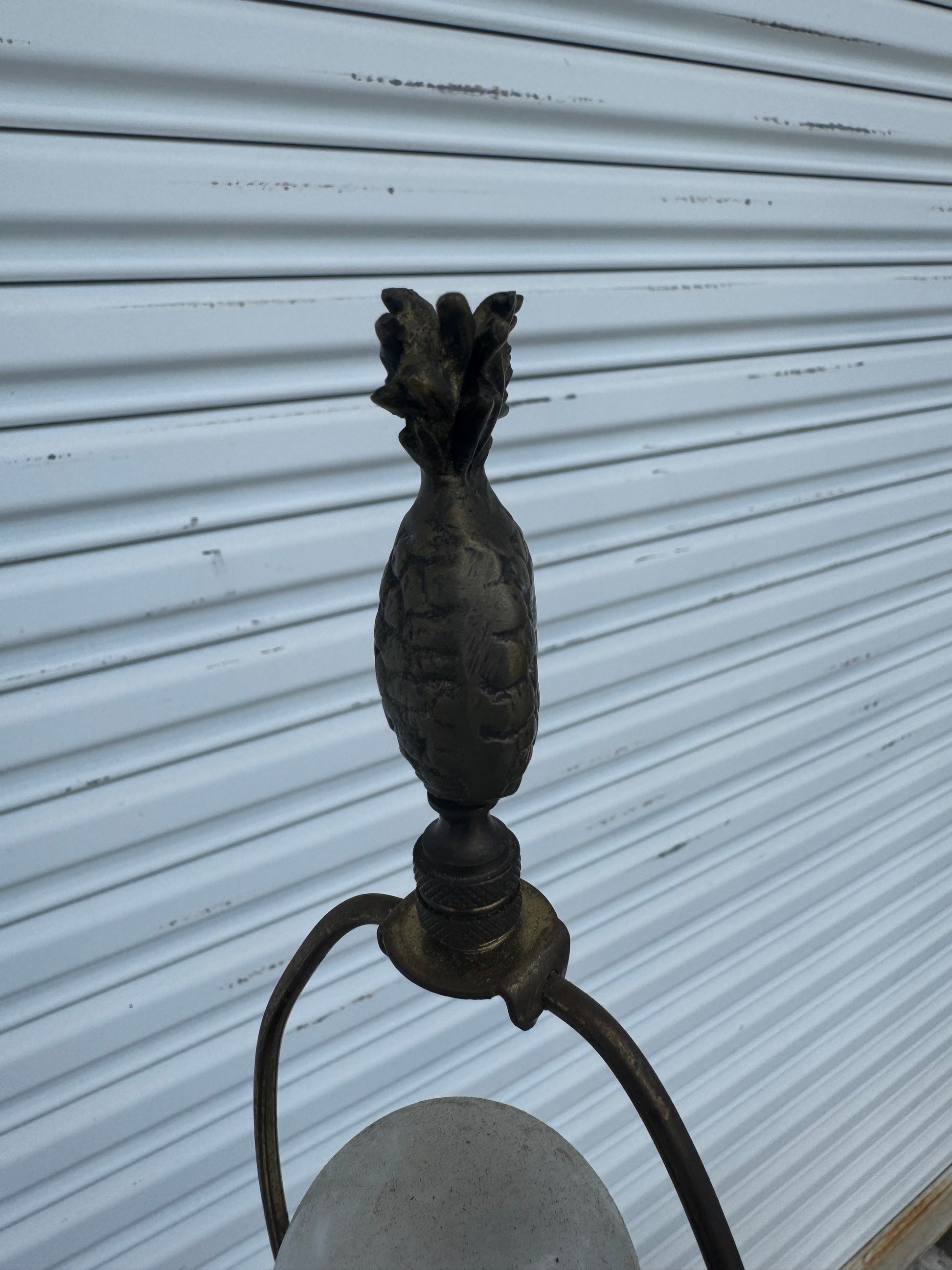 Detailed view of sculpted pineapple design and leaf embellishment on lamp, classic Regency style.