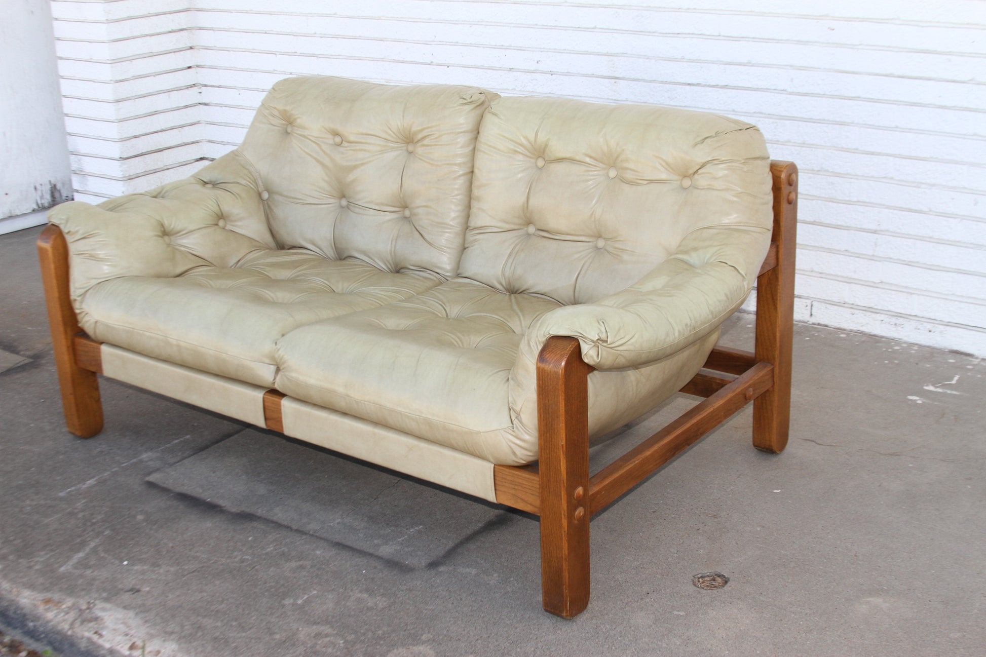 Stunning teak loveseat. Expertly crafted, this love seat sofa will elevate your decor with its timeless appeal. A rare gem among couches for sale.