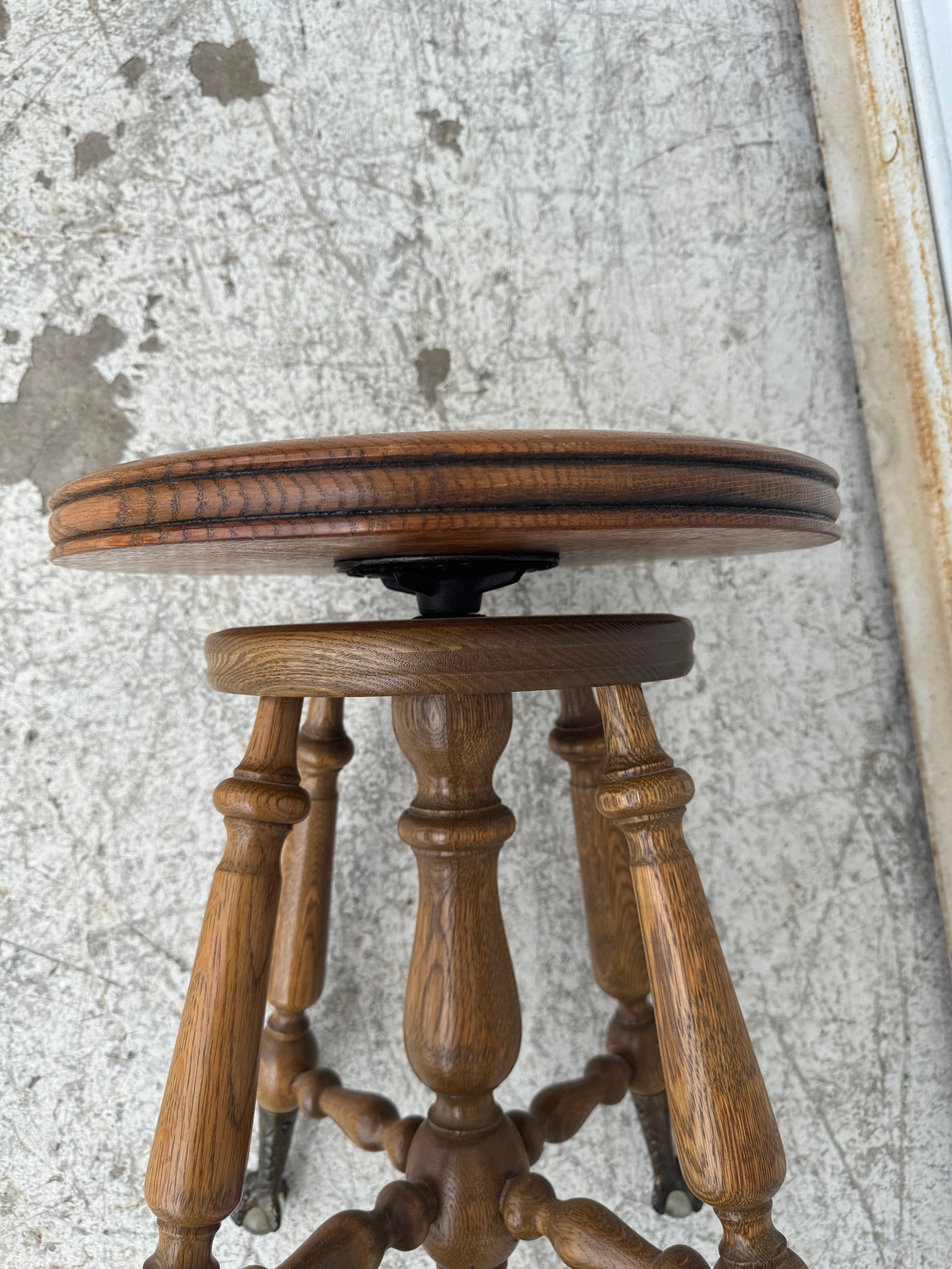 Detailed wood carving and craftsmanship on a Victorian-era adjustable piano stool.