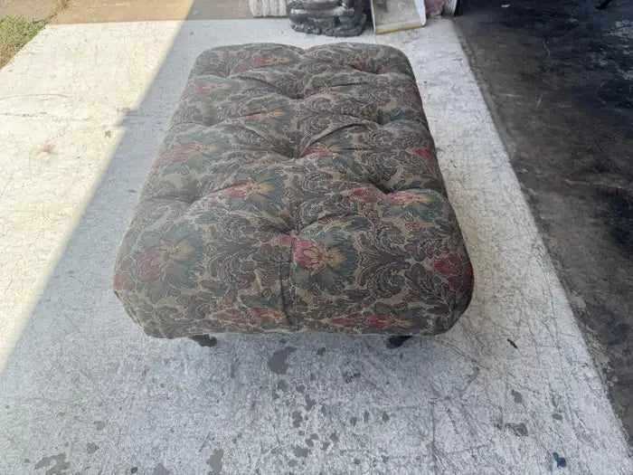 Upholstered footstool with classic tufted furniture design