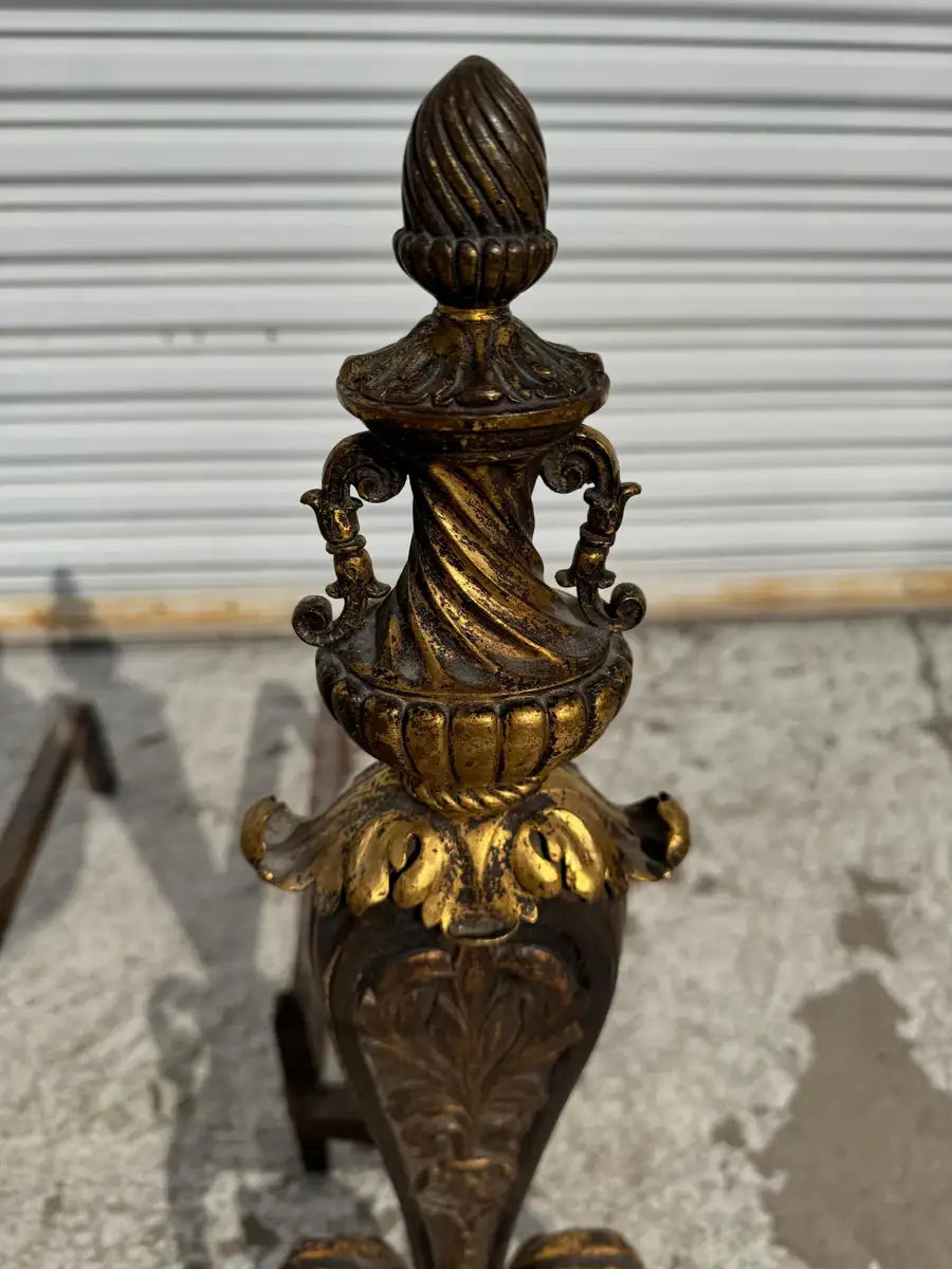 gilt iron andirons with decorative acanthus motif