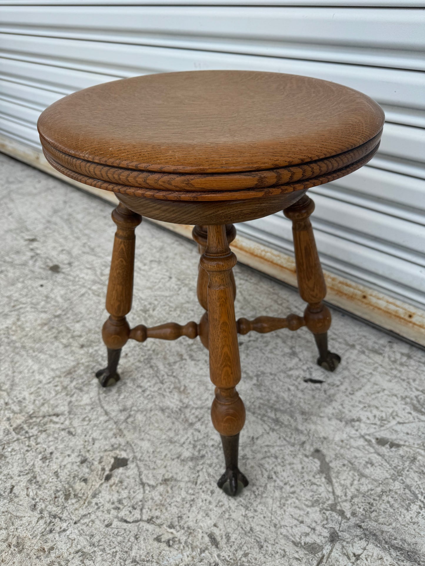 Classic oak piano stool with decorative turned stretchers and rich antique finish