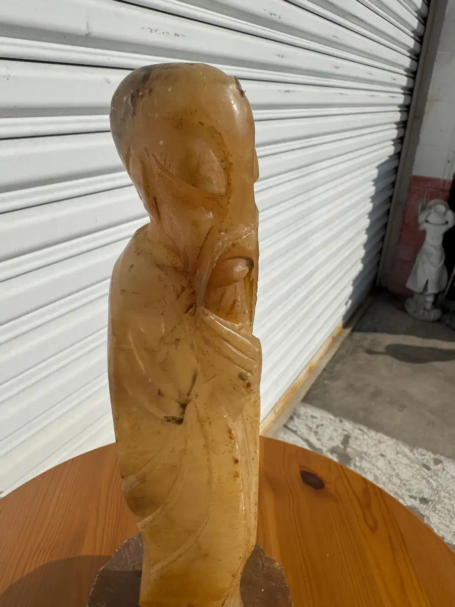 Carved stone monk sculpture serene meditation pose