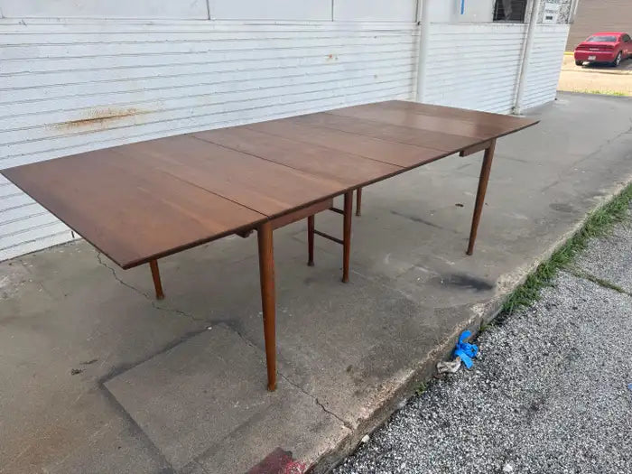 Walnut wood dining table with architectural silhouette