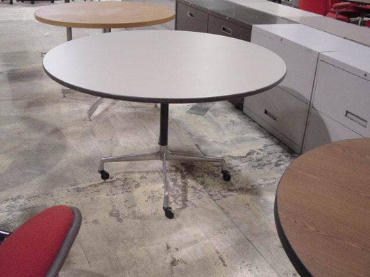 Herman Miller Eames 48-inch round roller dining table with mid century modern design and vintage roller base