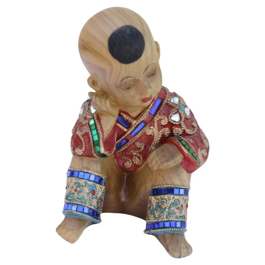 Carved wood seated figure in jeweled clothing